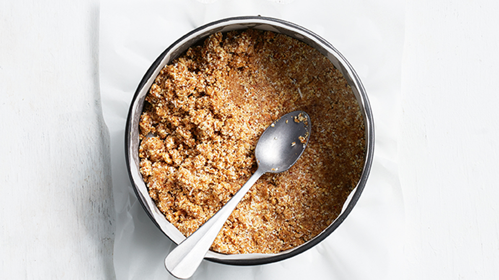 Using the back of the spoon to press the almond mixture into an even layer