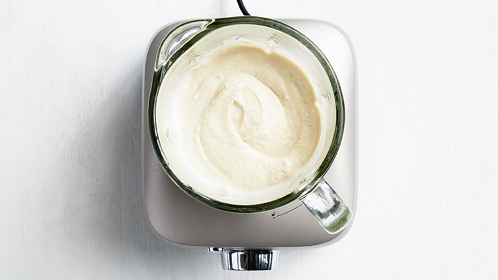 Using a blender to blitz the cashew mixture to a puree