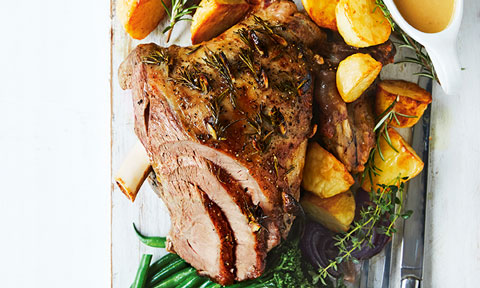 Roast lamb served with potatoes and vegetables