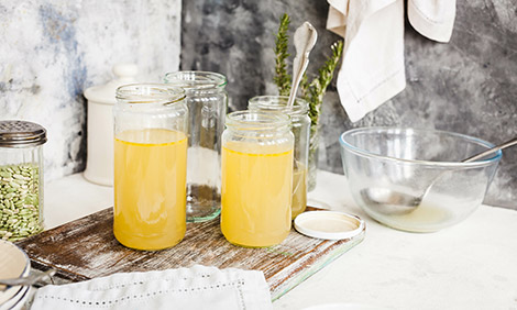 Meat stock in glass jars on a kitchen bench
