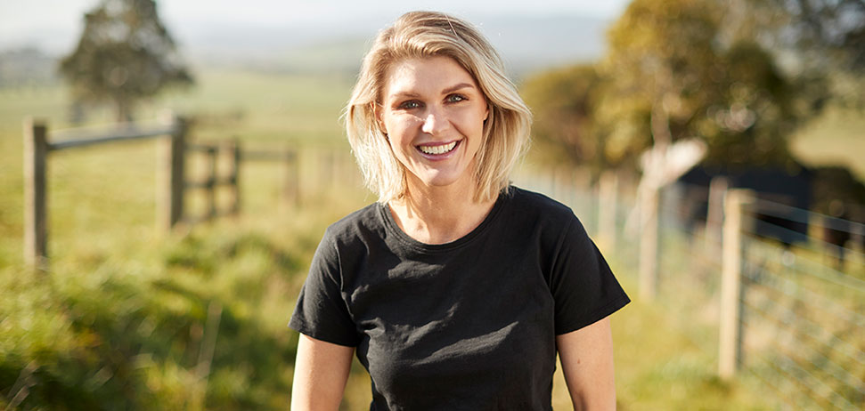 Courtney Roulston standing in a farm paddock