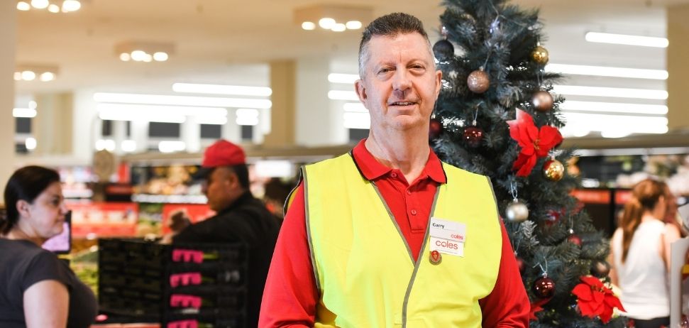 Store manager Garry Ackroyd standing in front of a Christmas tree
