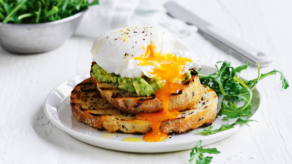 Poached egg on toast with avocado and rocket