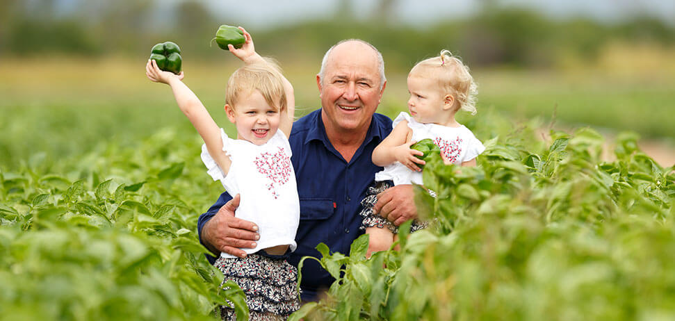 Des Chapman and family from Rocky Ponds, Gumlu, Queensland in field holding green capsicums