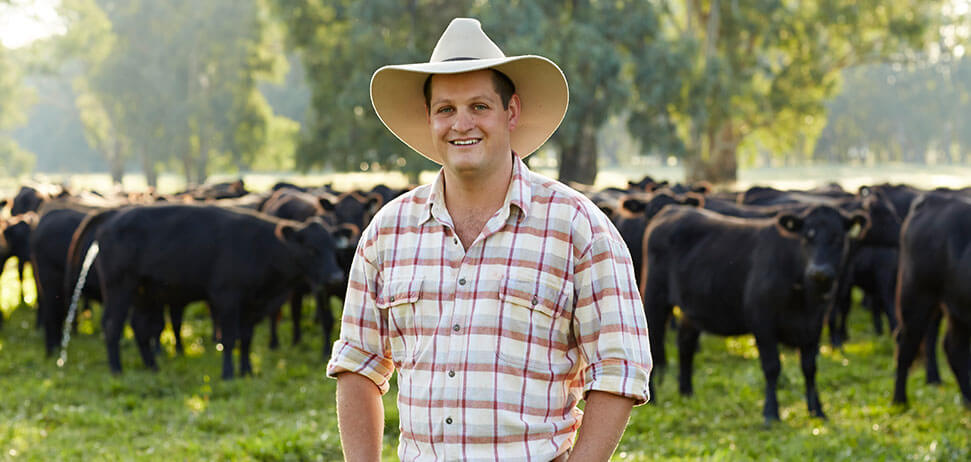 Beef farmer Nigel Stephens standing in front of a herd of cows at his farm 