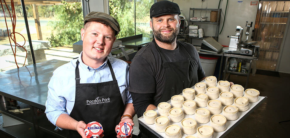 Two bakers from Pacdon Park in Echuca Victoria holding a tray of pork pies in a bakery