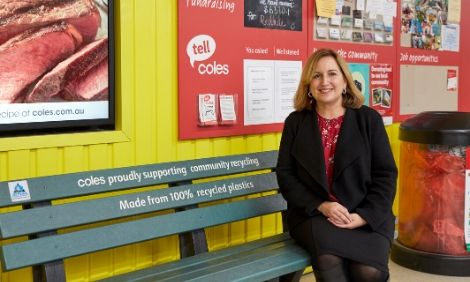 Woman sitting on bench smiling at camera 