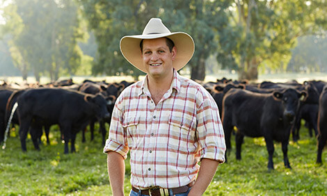 Beef farmer Nigel Stephens standing in front of a herd of cows at his farm 