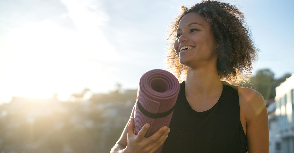 Woman holding yoga mat