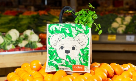 Koala designed bag on top of a shelf of fresh fruit