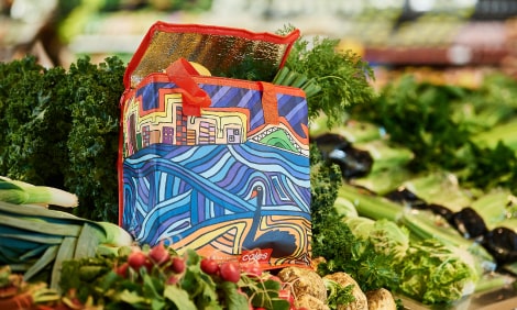 Perth city reusable bag on a shelf of fresh vegetables