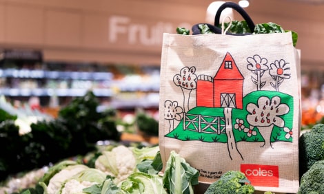 Farmyard design reusable bag on a shelf of fresh vegetables