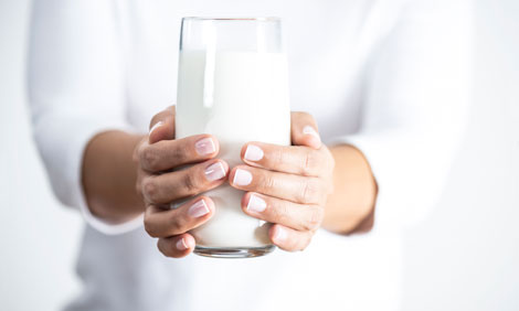 Someone holding a glass of milk