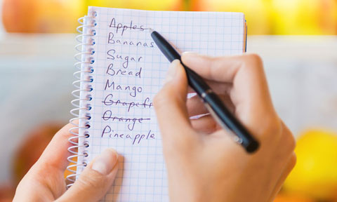Hand with pen writing shopping list
